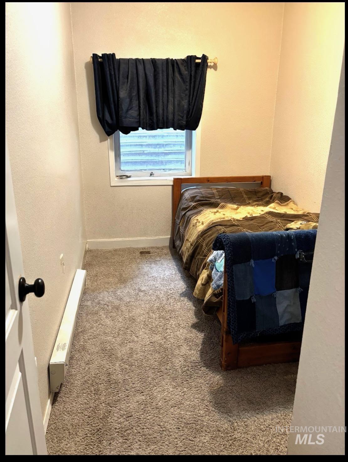409 North 7th Street Payette, ID 83661 - Photo 9 of 23 Compact room featuring neutral-toned walls, a window with a valance, and wall-to-wall carpeting