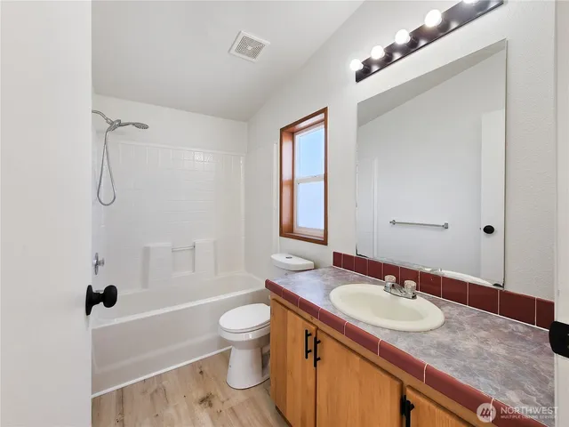a bathroom with a granite countertop sink toilet and shower
