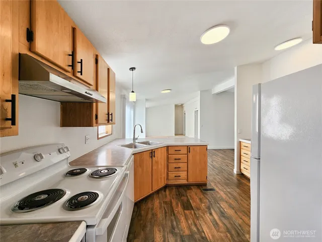 a kitchen with stainless steel appliances a stove a sink and a refrigerator
