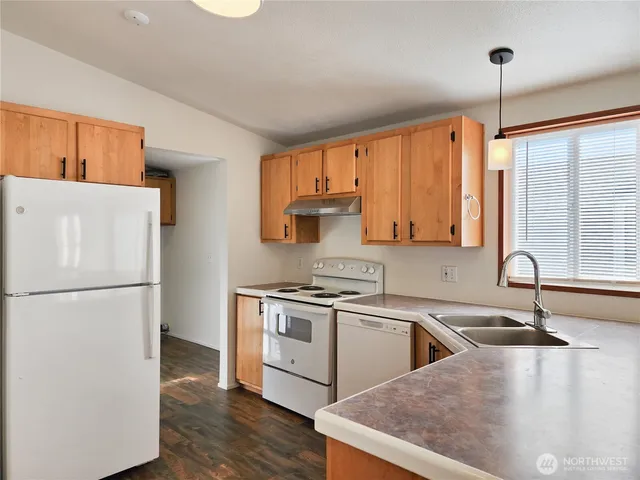 a kitchen with a sink a refrigerator and a stove top oven