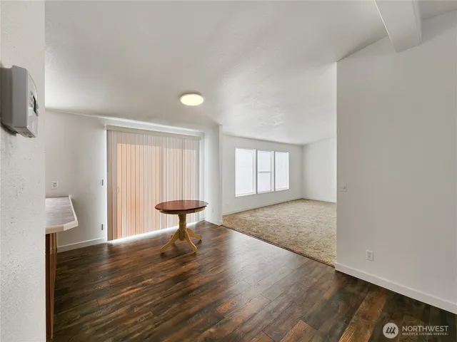 a view of empty room with a window and wooden floor