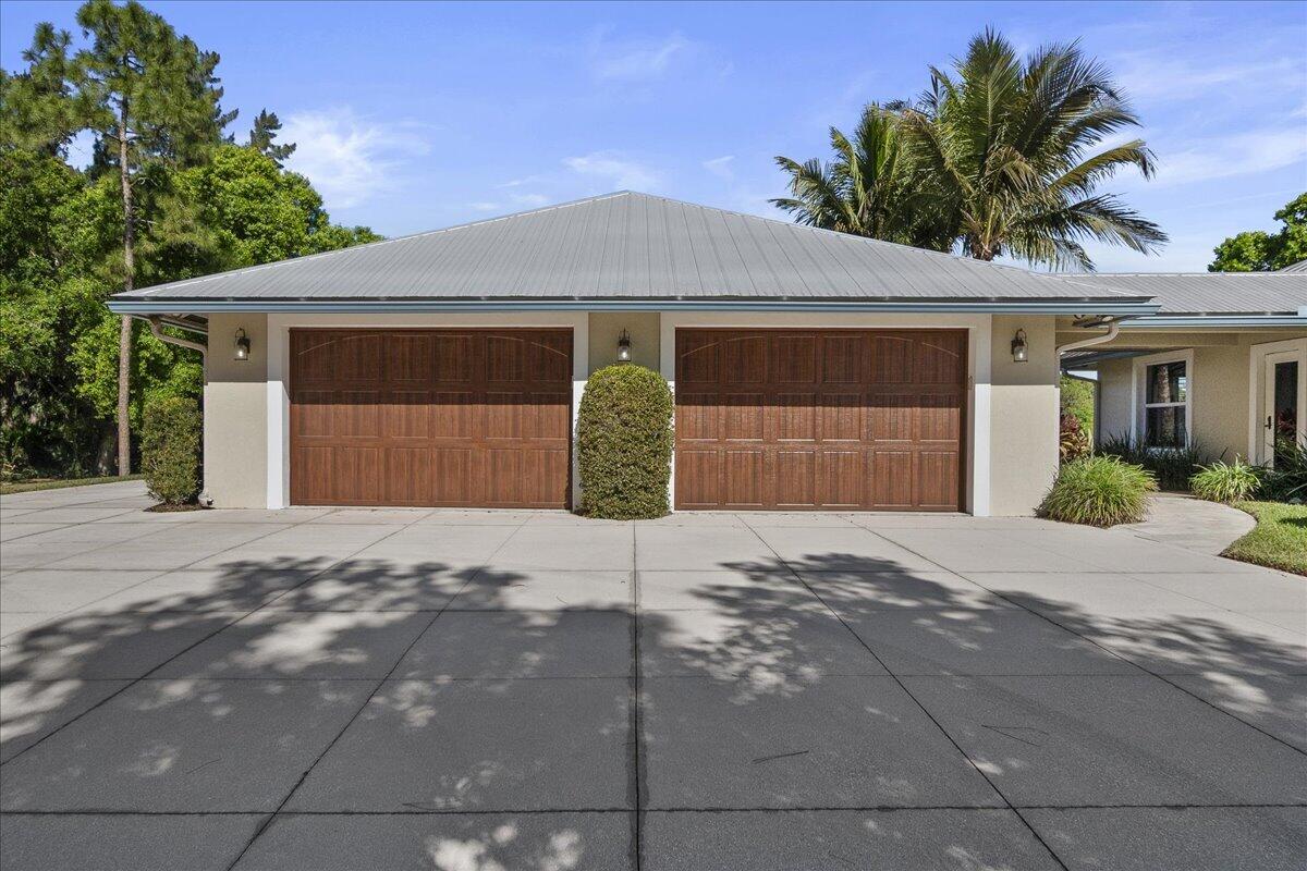 10975 Randolph Siding Road Jupiter, FL 33478 - Photo 7 of 97 a front view of a house with a yard and garage