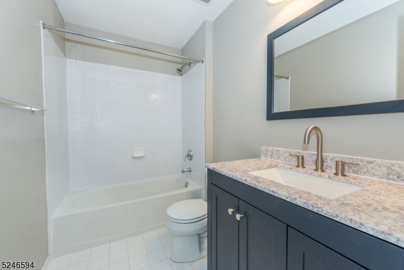 551 Coventry Drive Nutley, NJ 07110 - Photo 13 of 22 a bathroom with a granite countertop sink toilet and shower