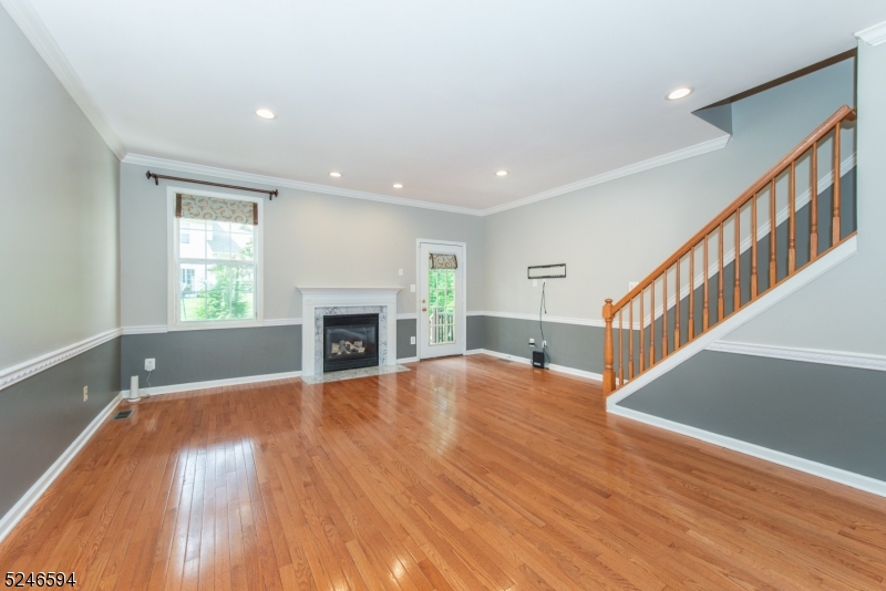 551 Coventry Drive Nutley, NJ 07110 - Photo 5 of 22 a view of an empty room with wooden floor fireplace and a window