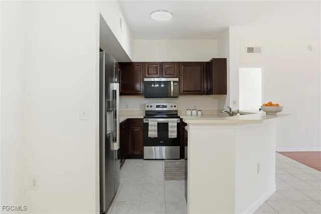 a kitchen with stainless steel appliances a refrigerator sink and microwave