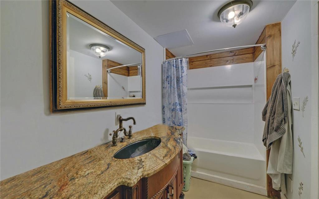 1330 Mc Cannon-Morris Road Colbert, GA 30628 - Photo 50 of 63 a bathroom with a granite countertop tub sink and mirror