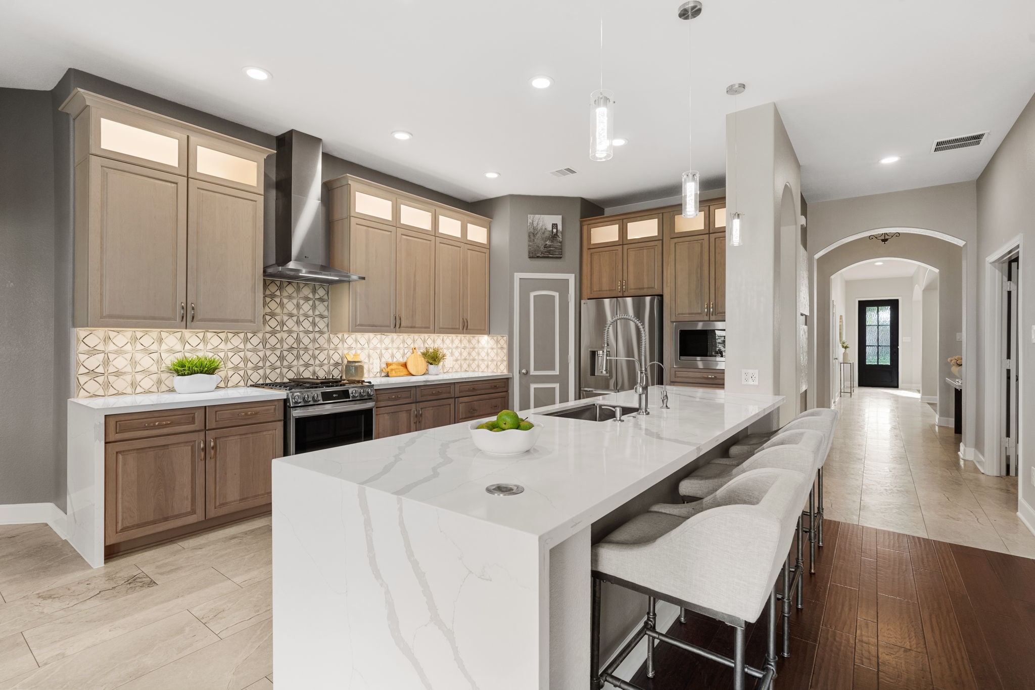 3426 Summer Ranch Drive Katy, TX 77494 - Photo 14 of 48 Thoughtfully designed with sleek quartz countertops, abundant cabinetry, and stainless steel appliances, this kitchen blends modern style with everyday functionality.