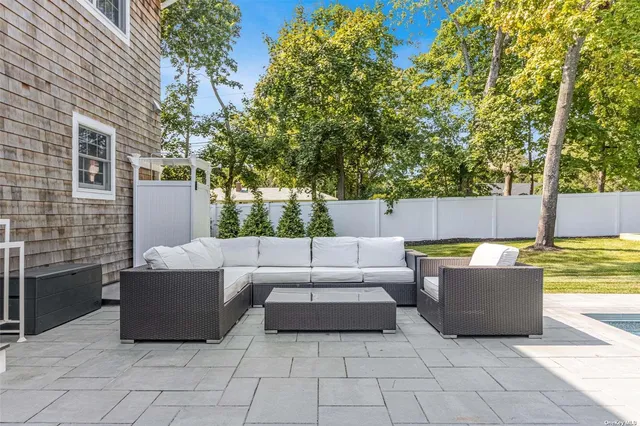 a view of a couches in the patio with a small yard