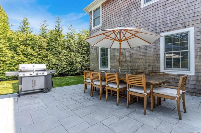 a backyard of a house with barbeque oven table and chairs