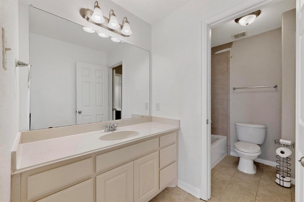 10309 Crowne Pointe Lane Fort Worth, TX 76244 - Photo 22 of 37 a bathroom with a sink a toilet and a mirror