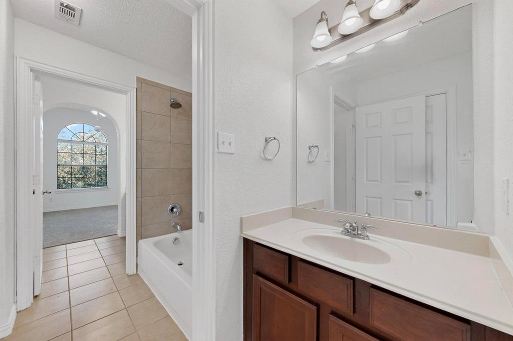 10309 Crowne Pointe Lane Fort Worth, TX 76244 - Photo 28 of 37 a bathroom with a sink a mirror and a shower
