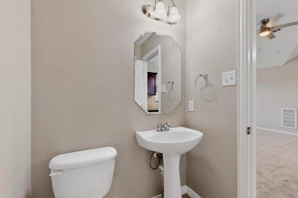 10309 Crowne Pointe Lane Fort Worth, TX 76244 - Photo 32 of 37 a bathroom with a toilet sink and mirror
