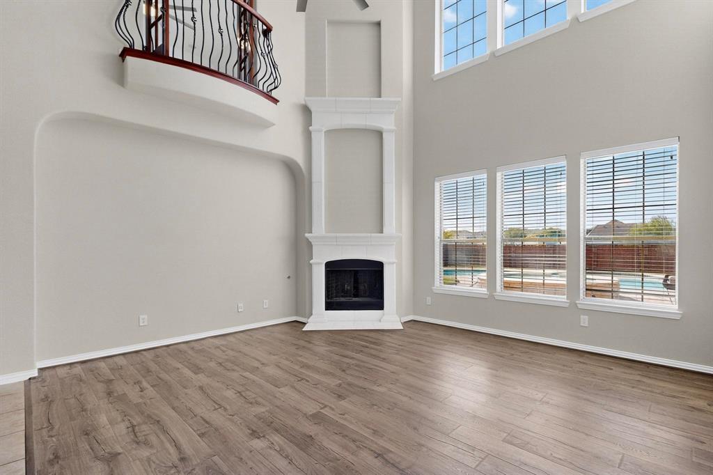 10309 Crowne Pointe Lane Fort Worth, TX 76244 - Photo 8 of 37 an empty room with wooden floor fireplace and windows