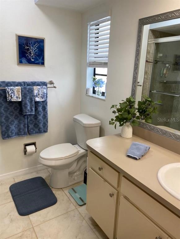 8437 Gibralter Street Spring Hill, FL 34608 - Photo 13 of 30 a bathroom with a toilet a sink and mirror