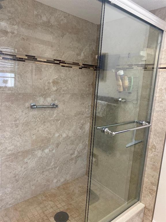 8437 Gibralter Street Spring Hill, FL 34608 - Photo 15 of 30 a bathroom with a glass shower door