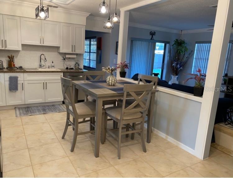8437 Gibralter Street Spring Hill, FL 34608 - Photo 16 of 30 a kitchen with kitchen island a sink table and chairs