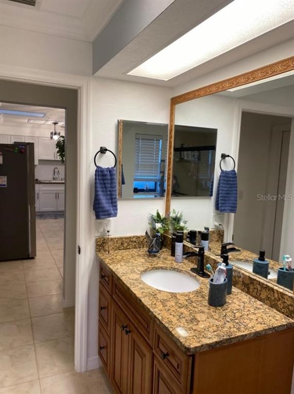 8437 Gibralter Street Spring Hill, FL 34608 - Photo 21 of 30 a bathroom with a granite countertop sink and a mirror