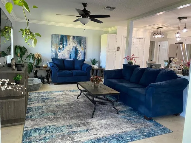 a living room with furniture and a chandelier
