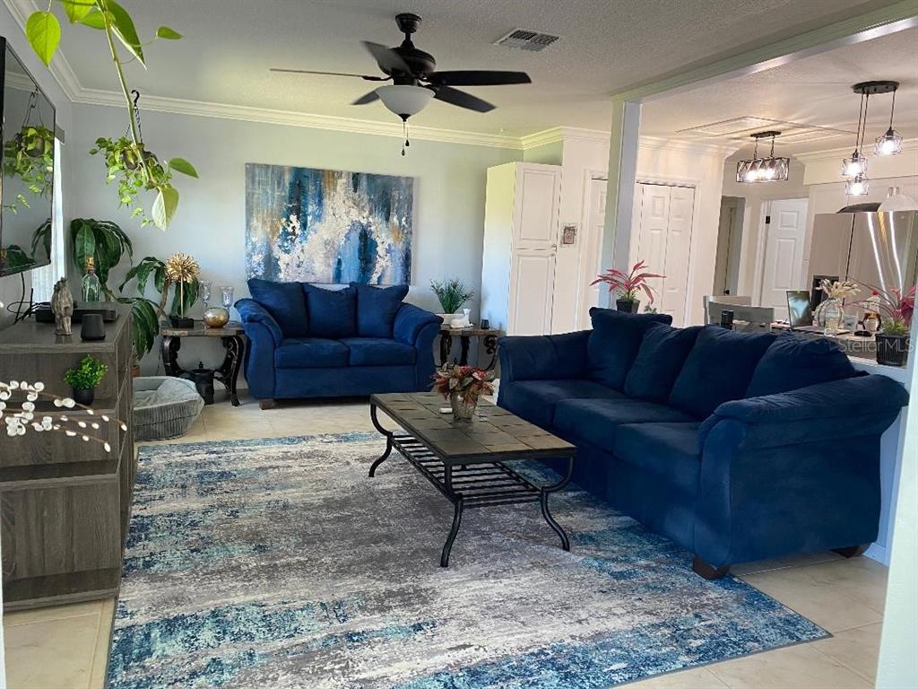8437 Gibralter Street Spring Hill, FL 34608 - Photo 23 of 30 a living room with furniture and a chandelier
