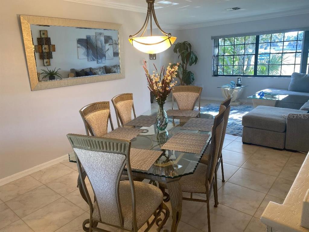 8437 Gibralter Street Spring Hill, FL 34608 - Photo 10 of 30 a view of a dining room with furniture wooden floor and a chandelier