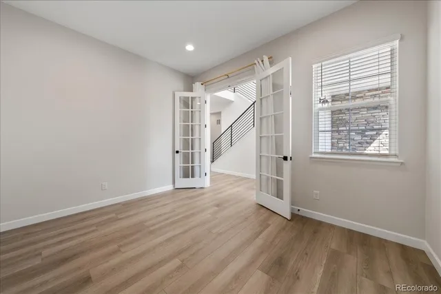 an empty room with windows and ceiling fan
