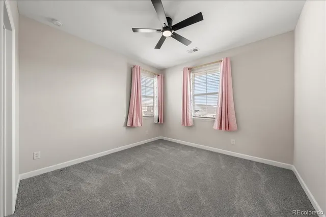 an empty room with closet and windows