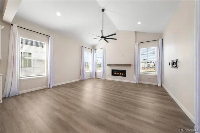 a view of an empty room with a fireplace and a window