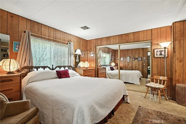 a large bedroom with bed and large windows