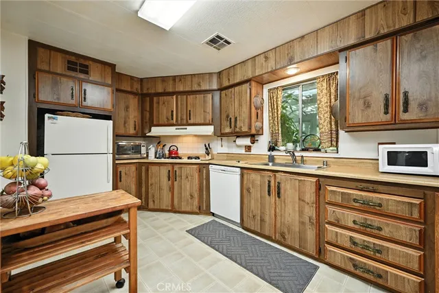 a kitchen with sink refrigerator and cabinets