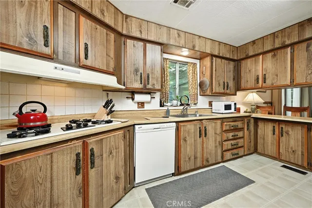 a kitchen with stainless steel appliances granite countertop a sink cabinets and a window
