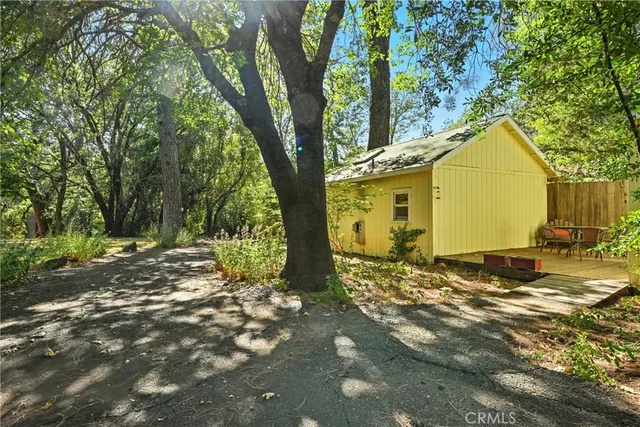 a view of a yard in front of a house with large tree