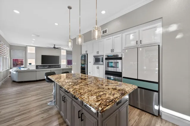 a kitchen with stainless steel appliances kitchen island granite countertop a stove and a refrigerator