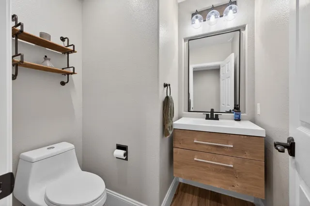 a bathroom with a toilet sink vanity and mirror