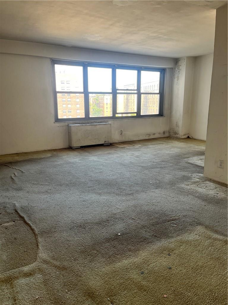 1020 Grand Concourse, Unit 8H Bronx, NY 10451 - Photo 11 of 13 Carpeted spare room featuring radiator heating unit