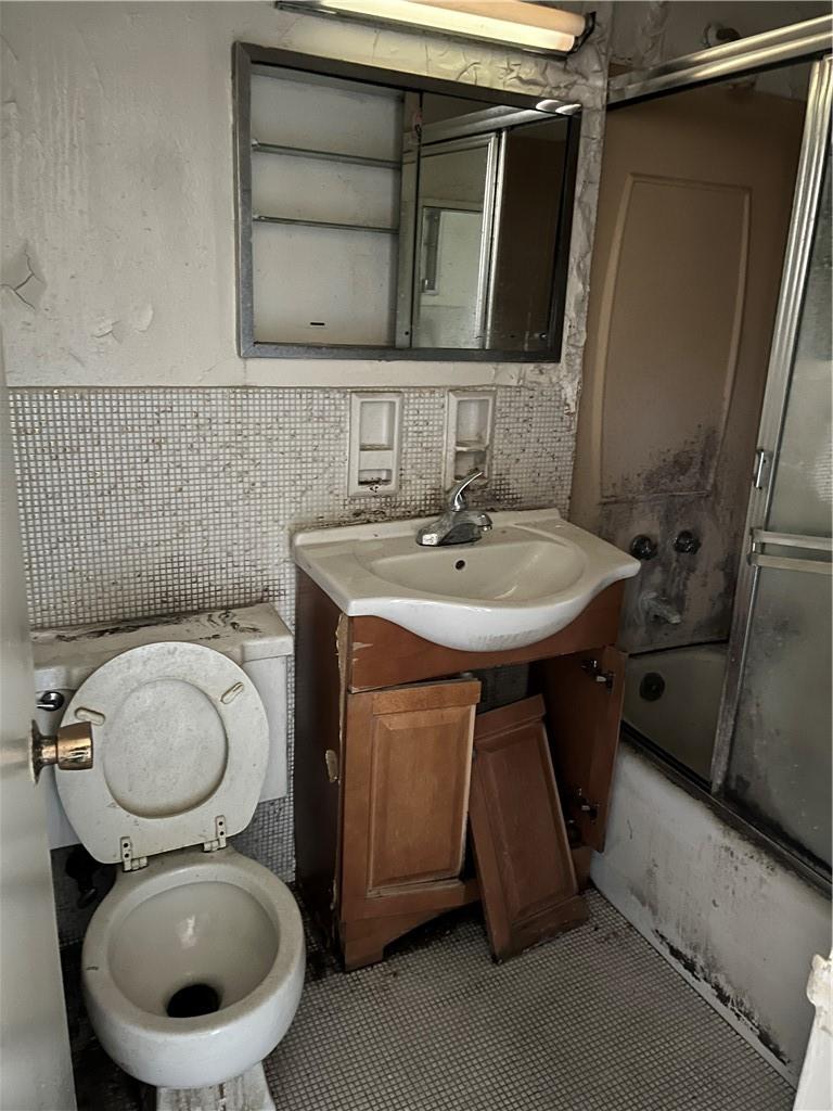 1020 Grand Concourse, Unit 8H Bronx, NY 10451 - Photo 3 of 13 Full bathroom featuring toilet, tile patterned flooring, tasteful backsplash, vanity, and tile walls