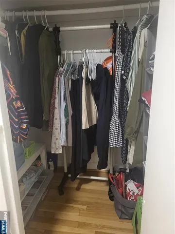 a view of walk in closet with clothes and shoes