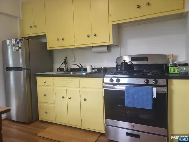 a kitchen with stainless steel appliances granite countertop a refrigerator and a stove
