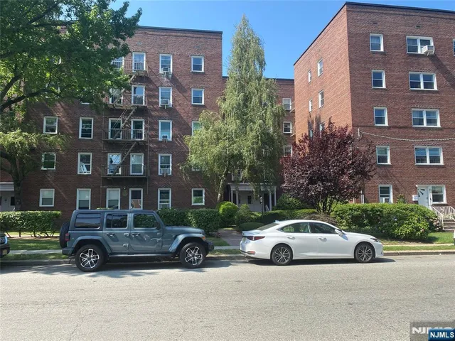 a view of a cars is parked in front of a brick building