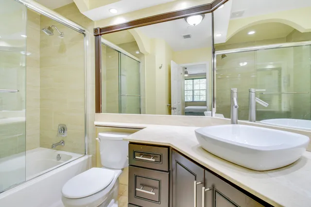 a bathroom with a granite countertop sink toilet and shower