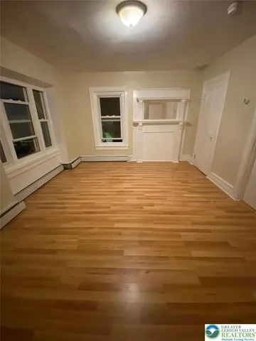 a view of an empty room with kitchen and sink
