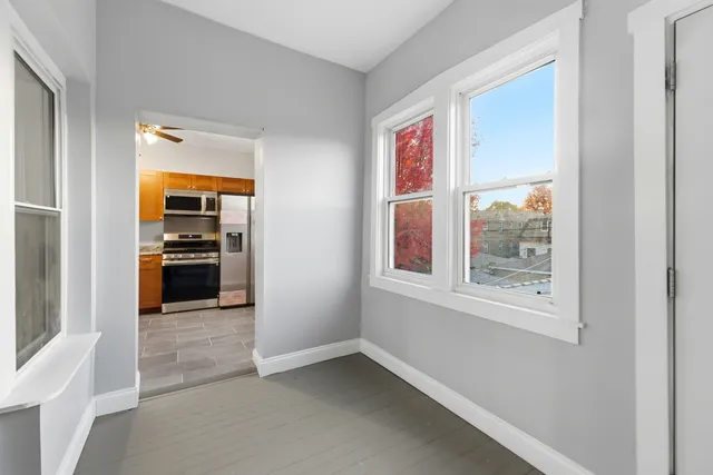 a view of a hallway with wooden floor and a living room