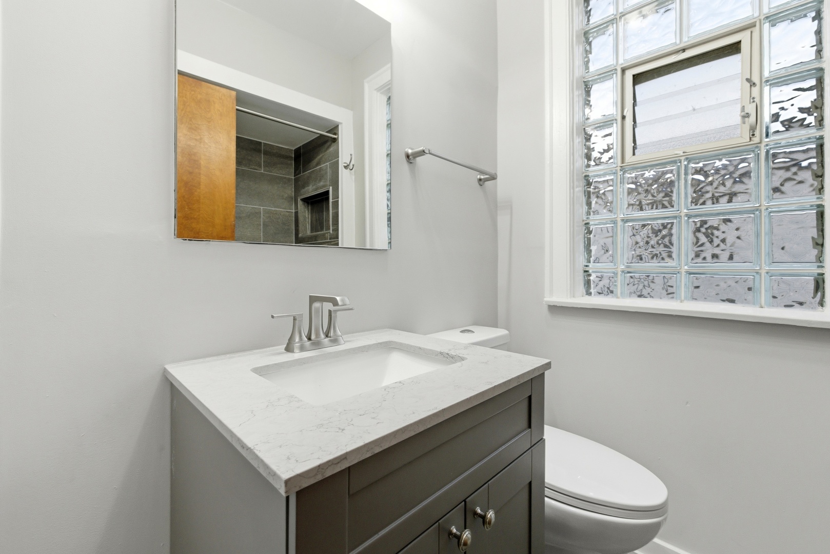 8344 South Marshfield Avenue Chicago, IL 60620 - Photo 18 of 35 a bathroom with a sink a mirror and a toilet