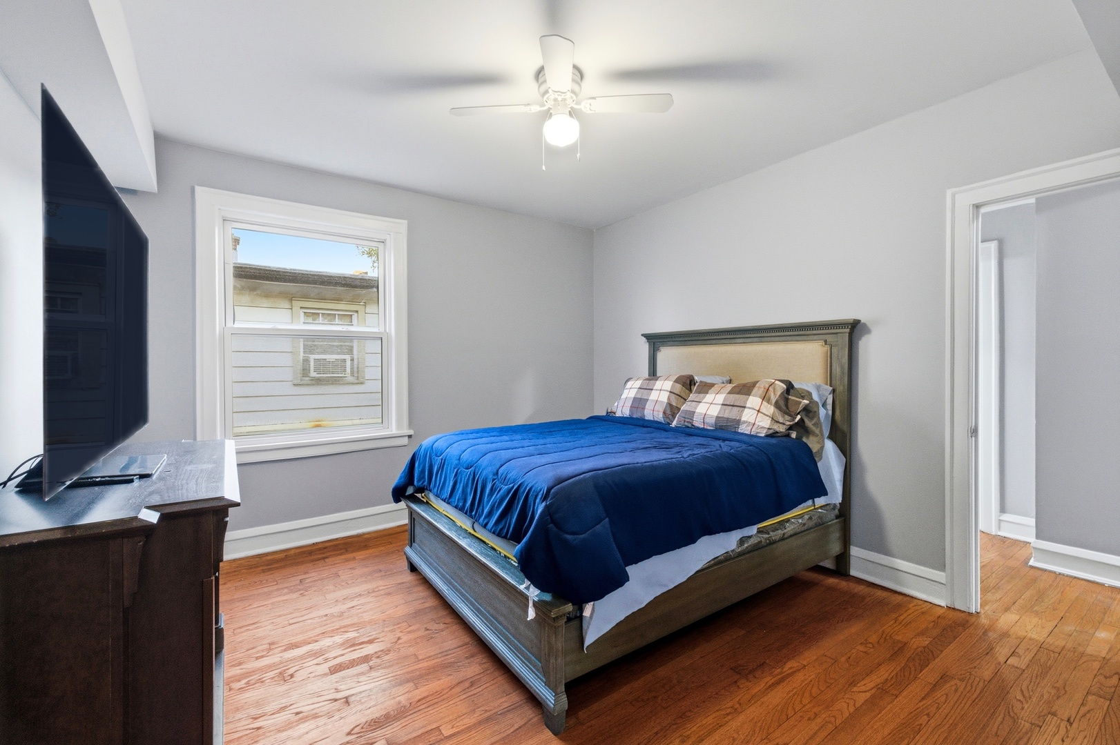 8344 South Marshfield Avenue Chicago, IL 60620 - Photo 20 of 35 a bedroom with a bed and a flat tv screen on dresser