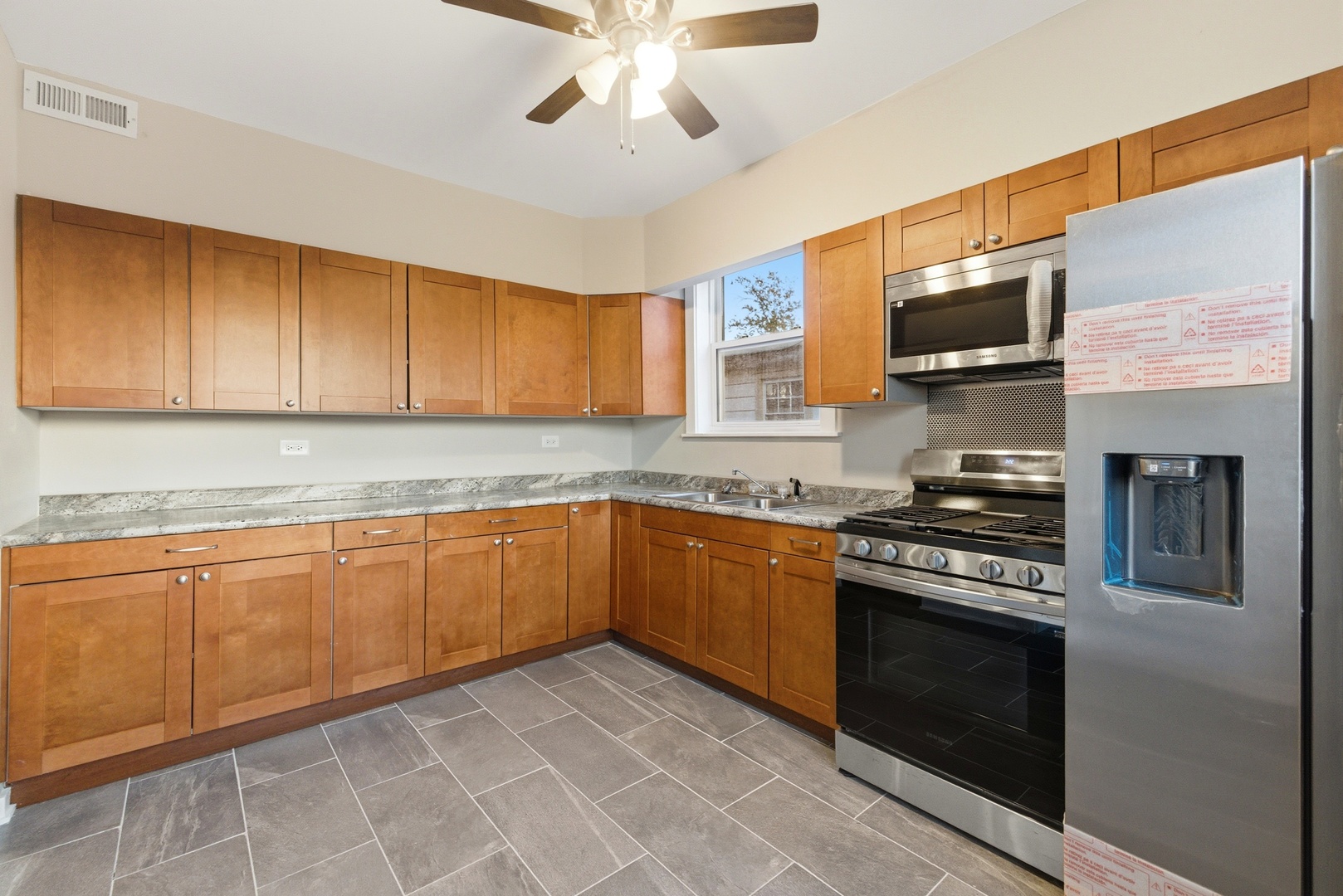 8344 South Marshfield Avenue Chicago, IL 60620 - Photo 9 of 35 a kitchen with granite countertop a stove top oven microwave and cabinets