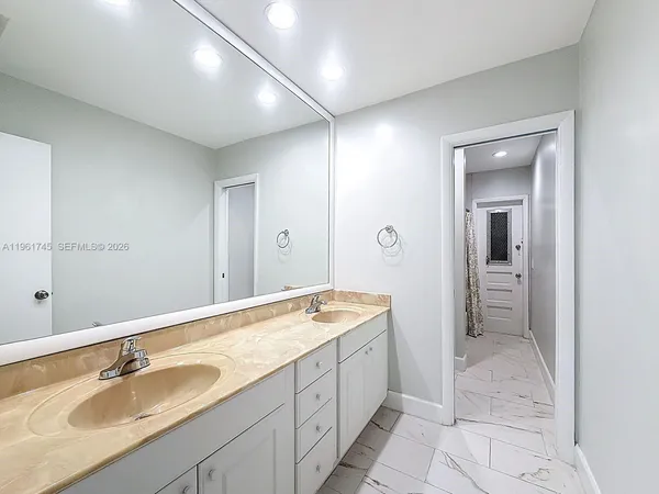 a spacious bathroom with a granite countertop sink and a mirror