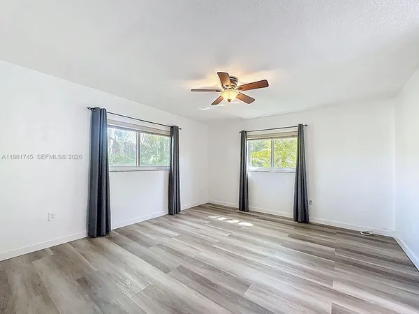 a view of a bedroom with a bed and a window