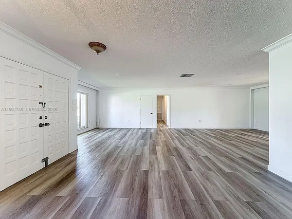 a view of a room with wooden floor and window