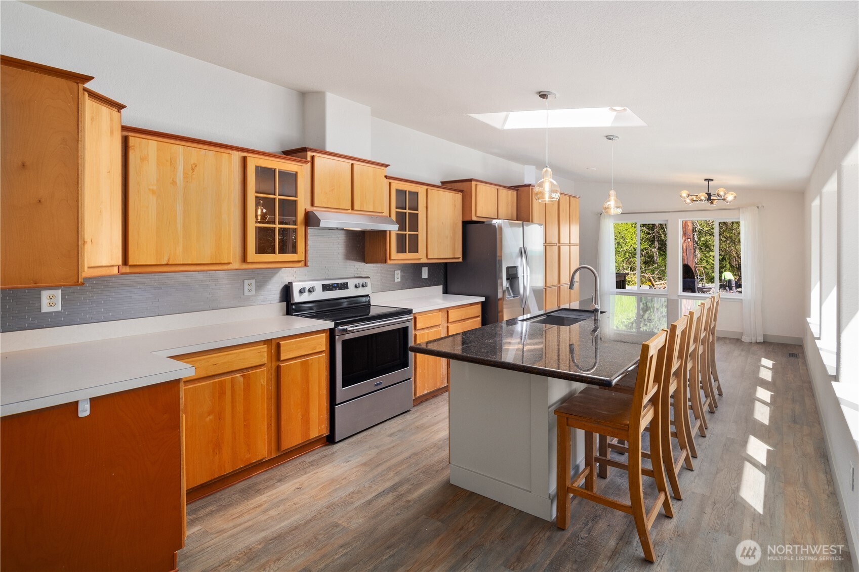408 South Saylor Road Camano Island, WA 98282 - Photo 6 of 38 a kitchen with stainless steel appliances granite countertop wooden cabinets a sink a stove a dining table and chairs