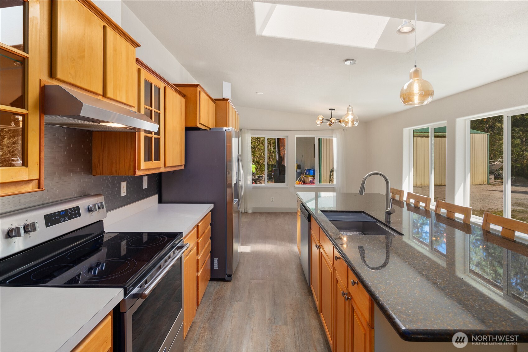 408 South Saylor Road Camano Island, WA 98282 - Photo 9 of 38 a kitchen with stainless steel appliances granite countertop a stove a sink dishwasher and cabinets with wooden floor