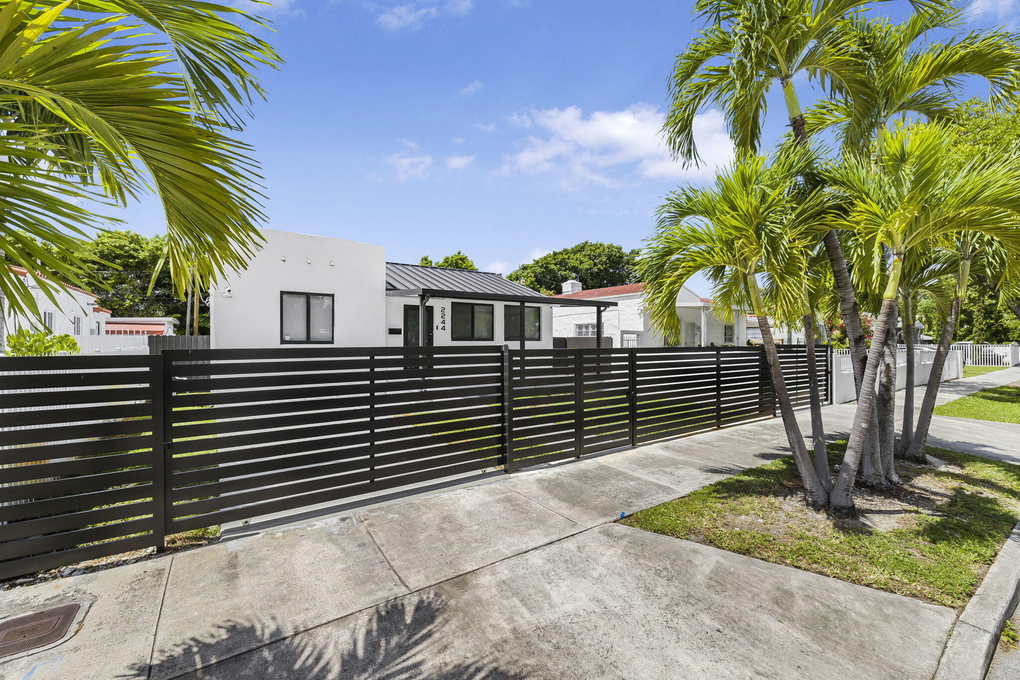 a view of a house with a yard and potted plants